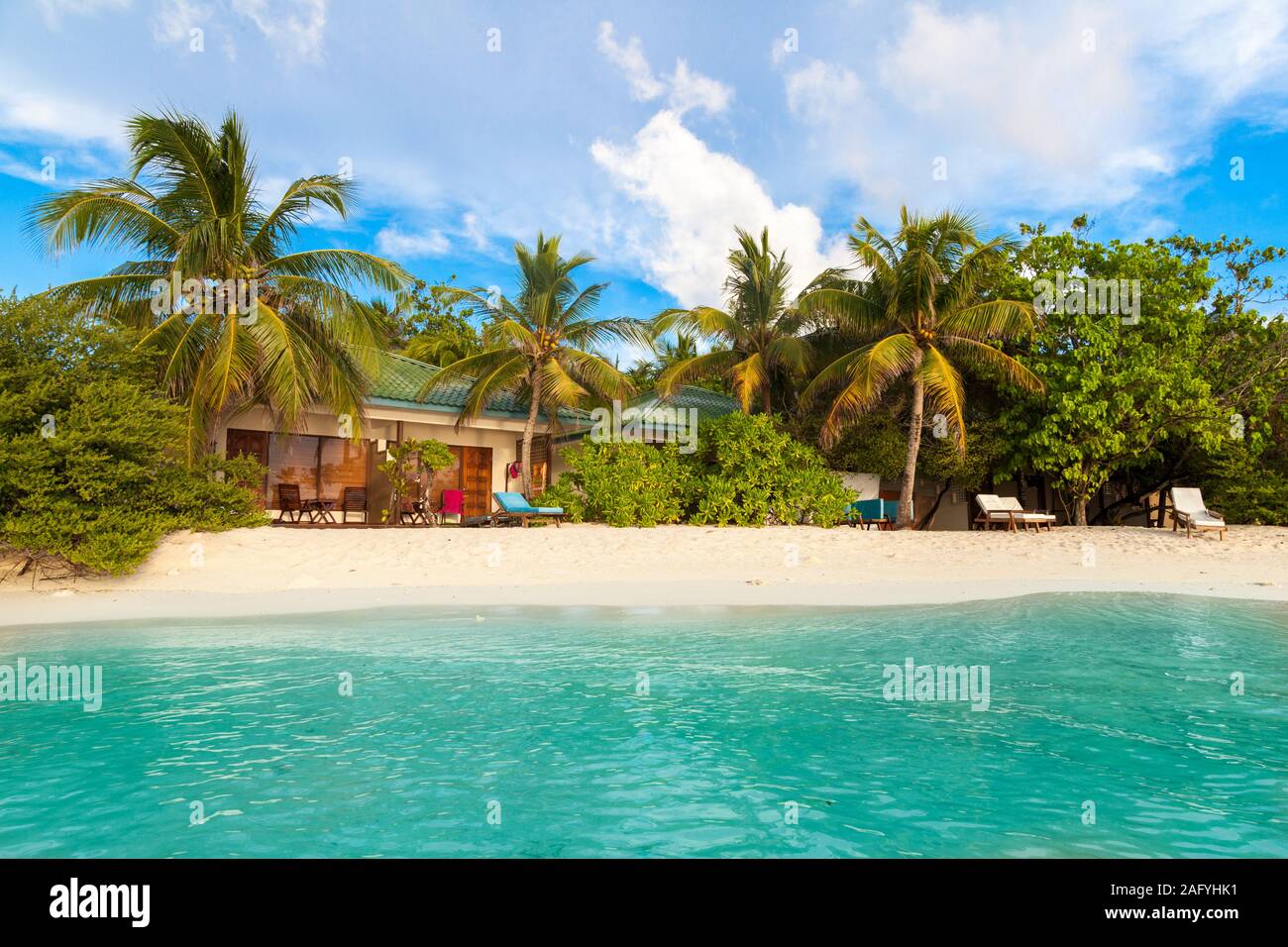 Une plage aux Maldives avec du sable blanc et de magnifiques palmiers ...