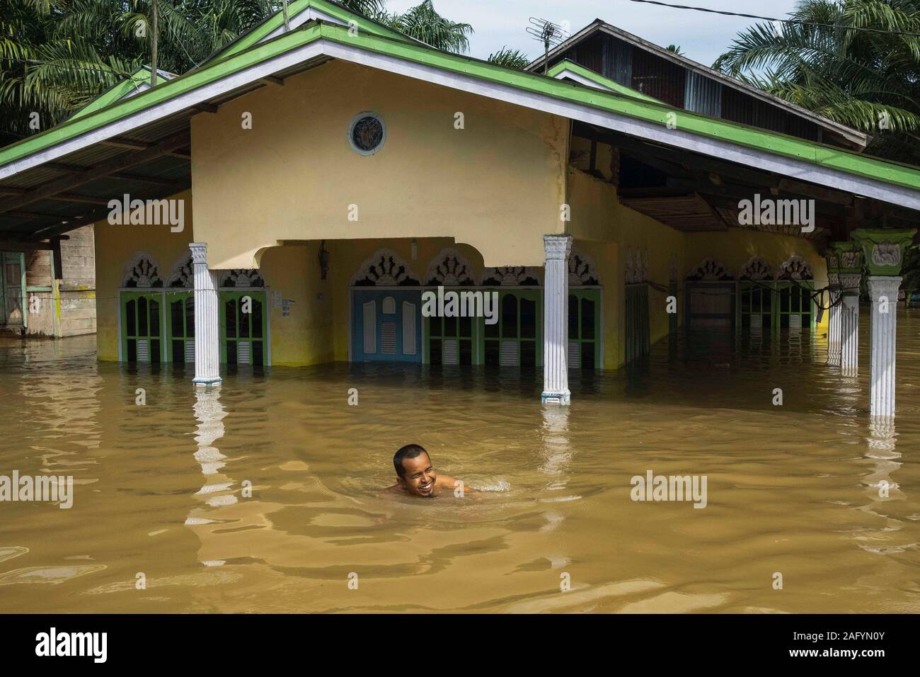 Riau, l'Indonésie. 25Th Dec 2019. Un homme nage dans l'eau d'inondation à Wisata Buluh Cina village dans le district de Kampar, Riau, l'Indonésie, le 17 décembre 2019. Credit : Afrianto Silalahi/Xinhua/Alamy Live News Banque D'Images