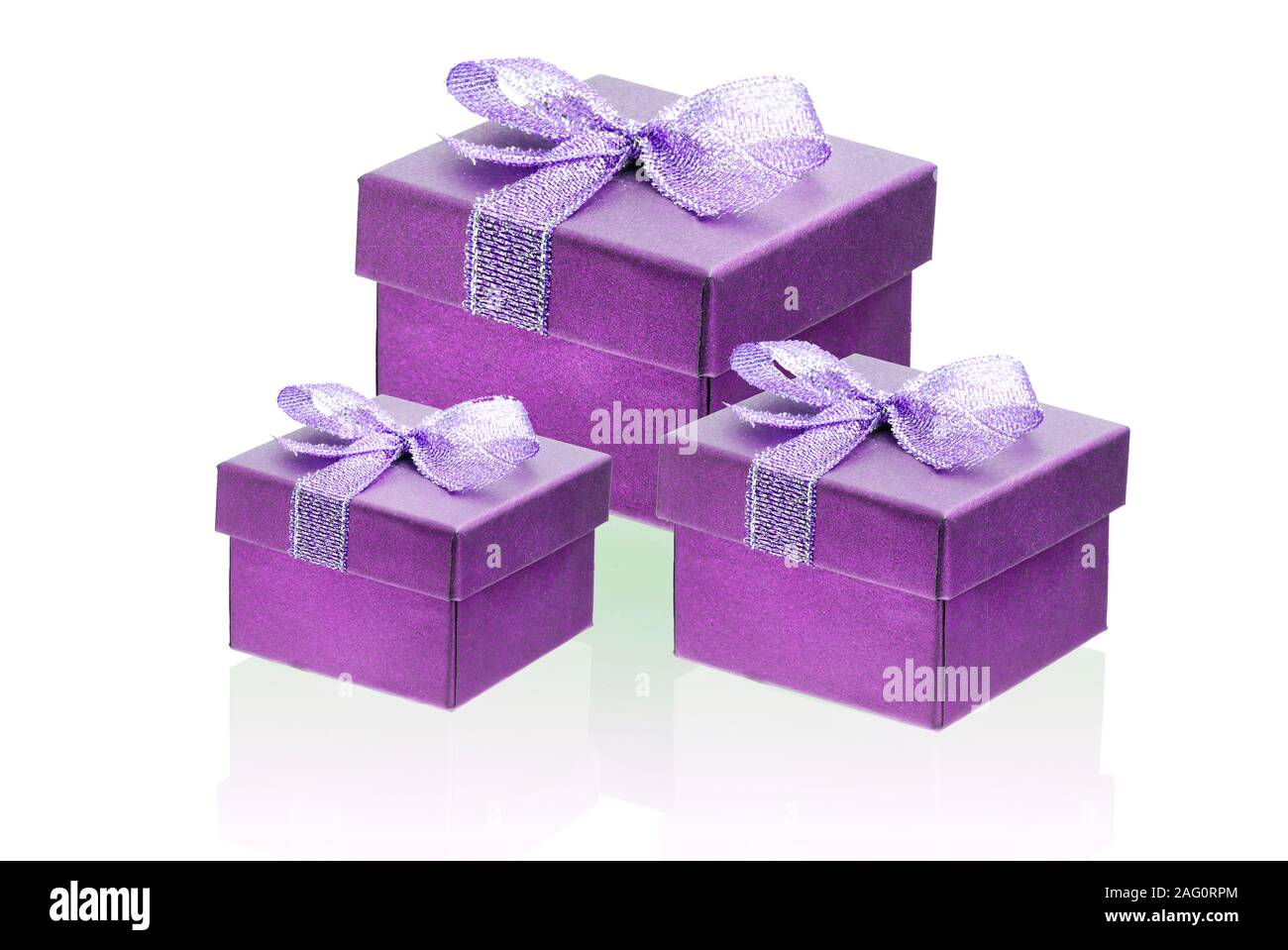 Trois chaud rose, violet boîtes cadeaux isoler sur un fond blanc, close-up, de réflexion. Banque D'Images