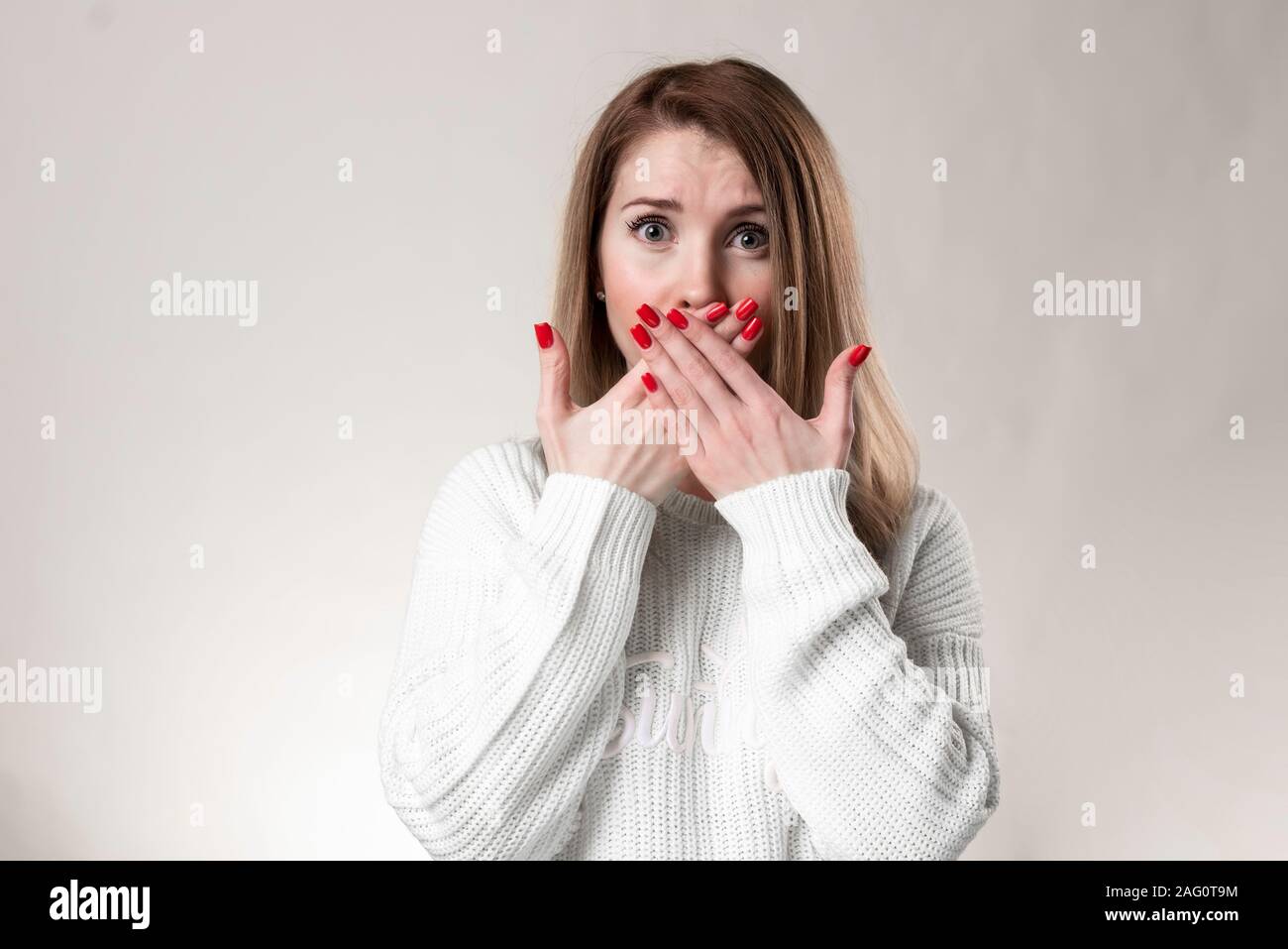 Fille assez rit et couvre sa bouche Banque D'Images