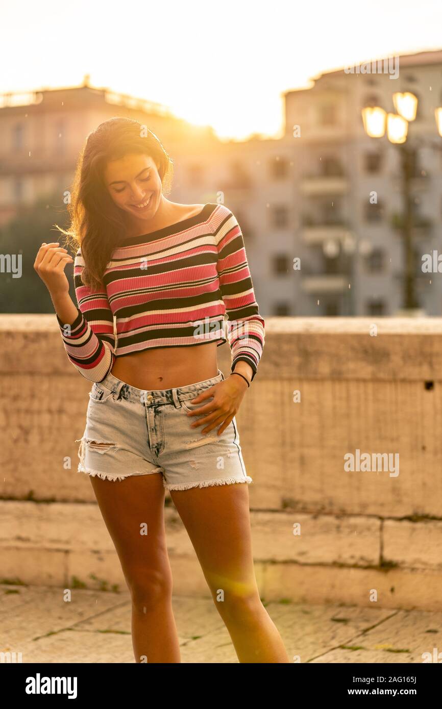 Belles femmes caucasiennes smiling in city dans le coucher du soleil Banque D'Images