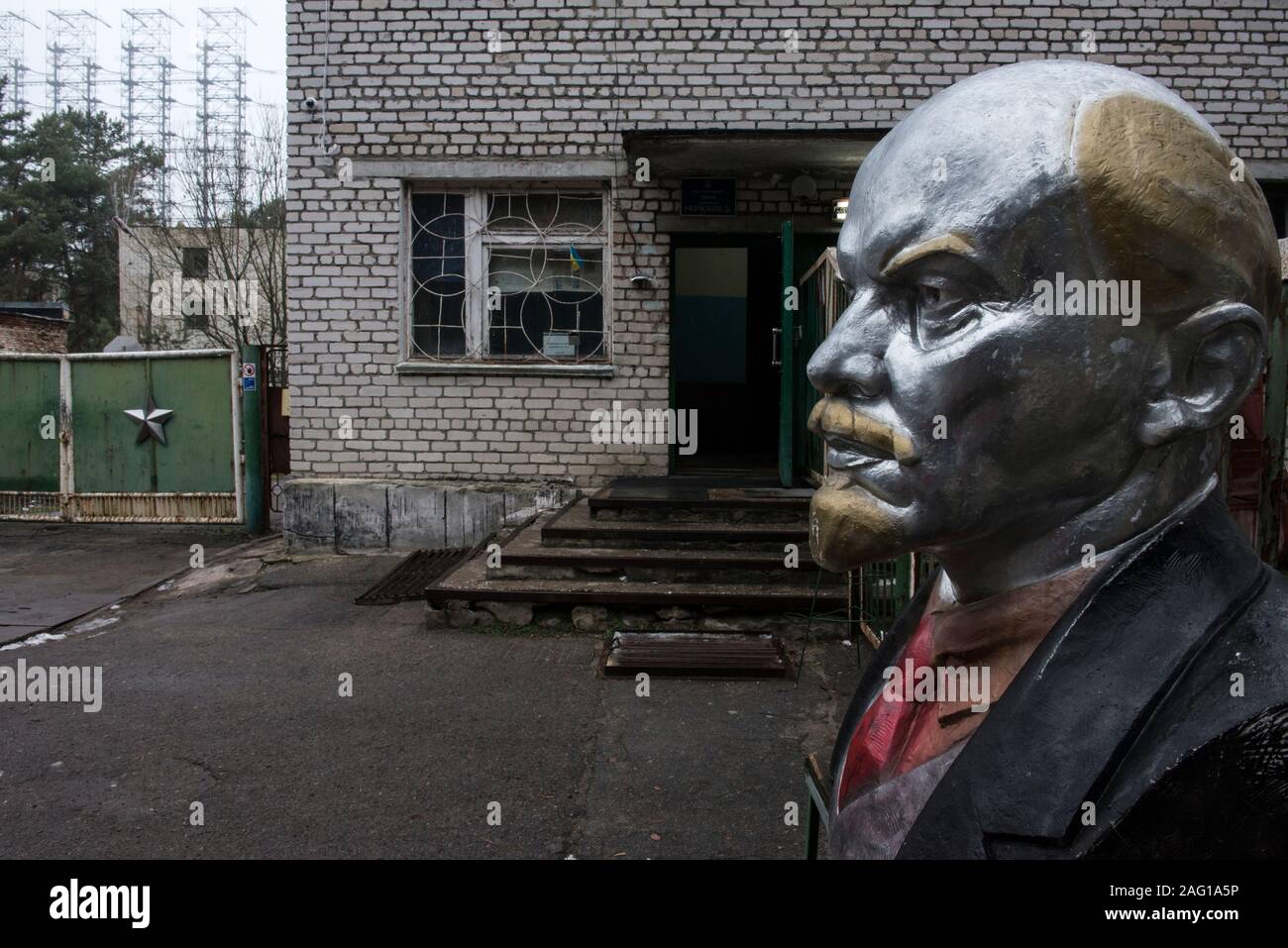 Buste de Wladimir Iljitsch Lénine à l'entrée de la zone de la Duga-1 (également appelé AUTR-1 ou pic russe) près de Tchernobyl dans la zone d'exclusion de Tchernobyl. Dans l'arrière-plan est vu la Duga-1. L'OTH est un construit, au cours de l'horizon radar pour détecter les lancements de missiles balistiques intercontinentaux. La construction a commencé en mars 1972. Les premières émissions de cette installation ont été lus au 4e juillet 1976. Dans la matinée du 26 avril 1986 les opérations du radar à l'arrêt. Zone d'exclusion de Tchernobyl, Invankiv, Kiev Kiev oblast, Ukraine, Europe de l'Est Banque D'Images