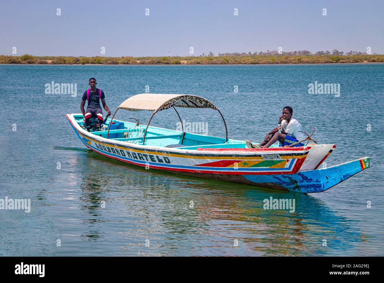 Lagune de Somone, Sénégal- le 26 avril 2019 : deux garçons sur un voile coloré en bois typique du canot dans le Sénégal, l'Afrique. Banque D'Images