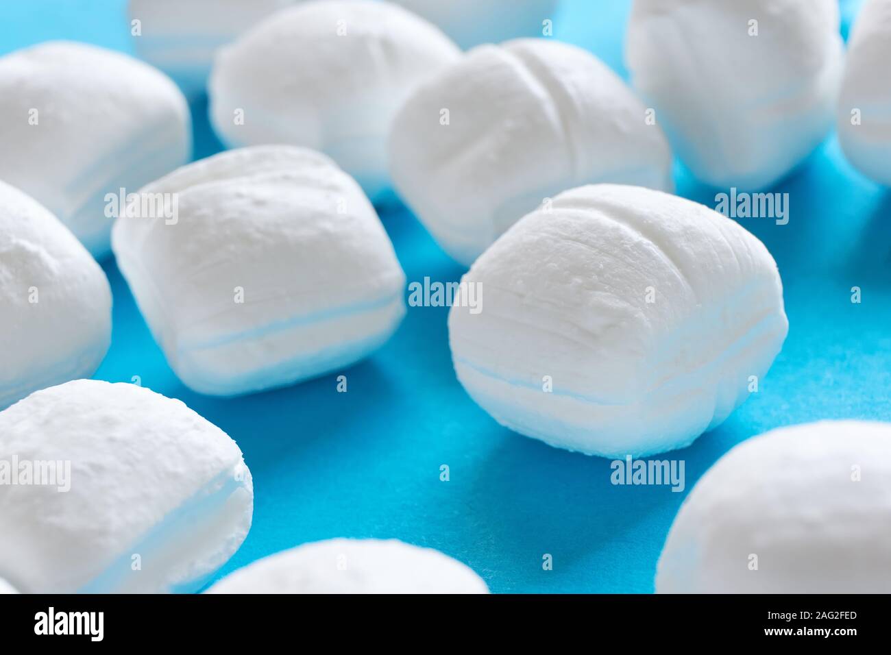 Close-up of white menthe bonbons ou cassants Peppermint Candy sur fond bleu Banque D'Images