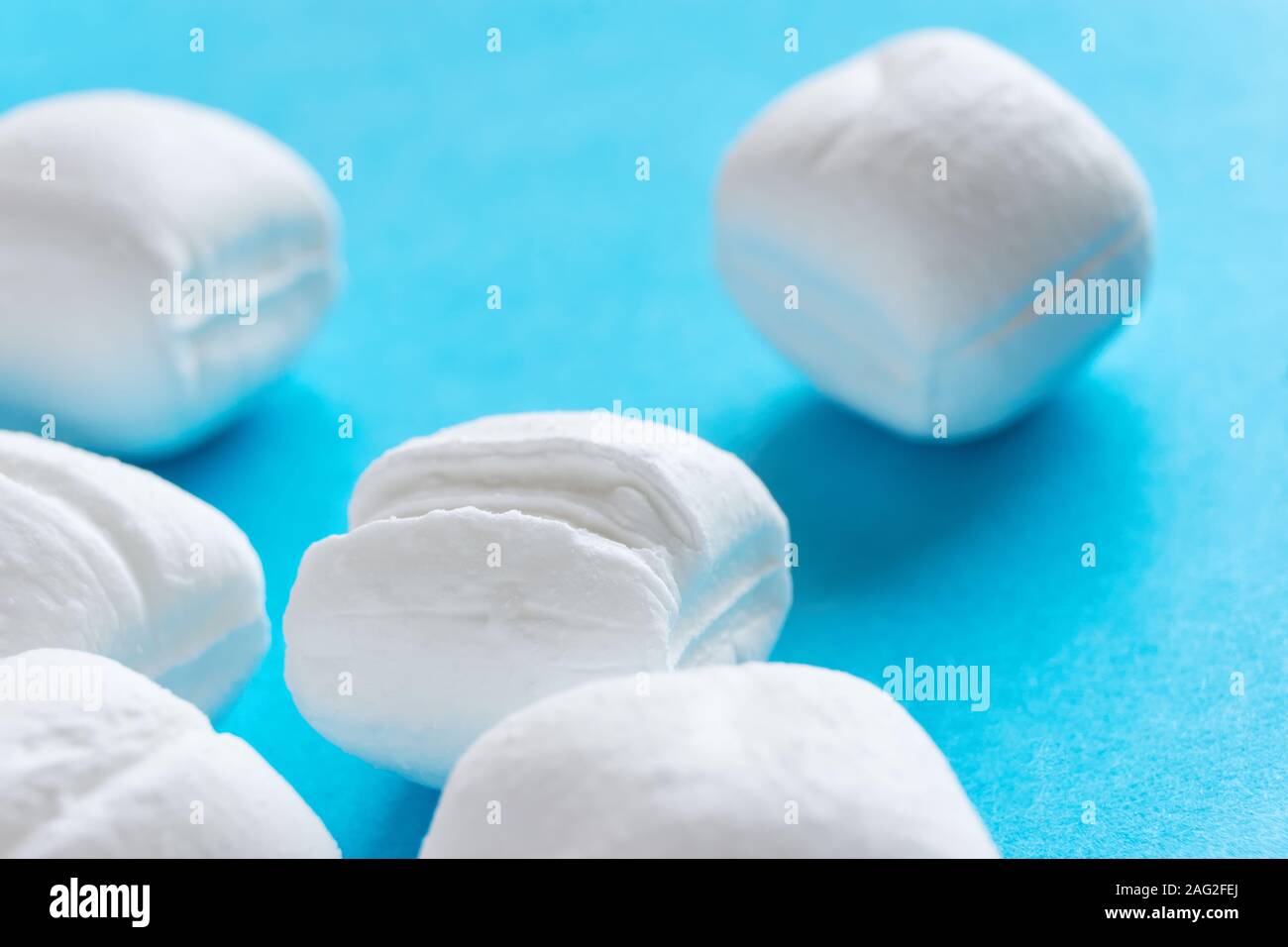 Close-up of white menthe bonbons ou cassants Peppermint Candy sur fond bleu Banque D'Images