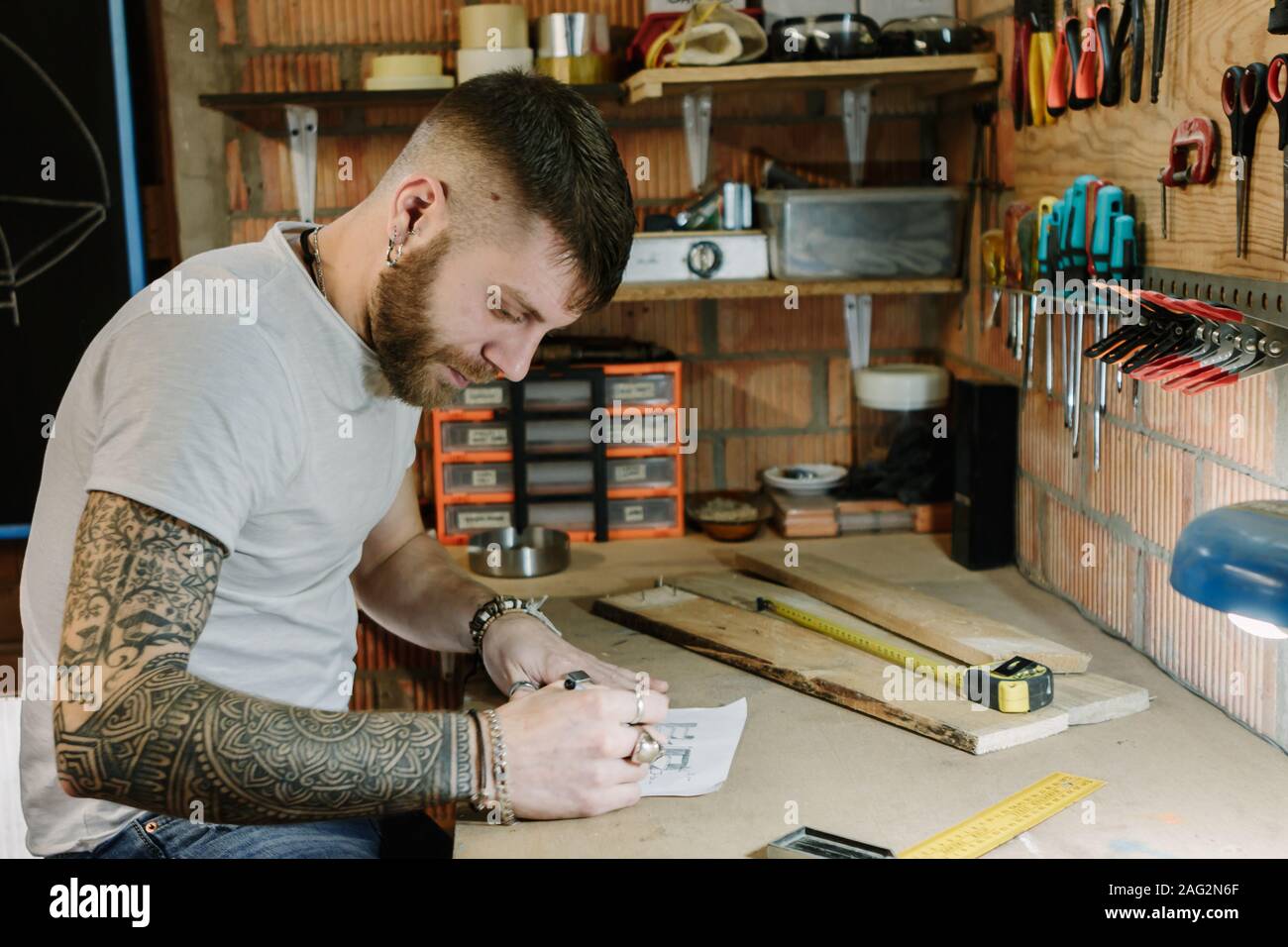Carpenter barbu dessin soigneusement son projet à l'atelier d'artisanat Banque D'Images