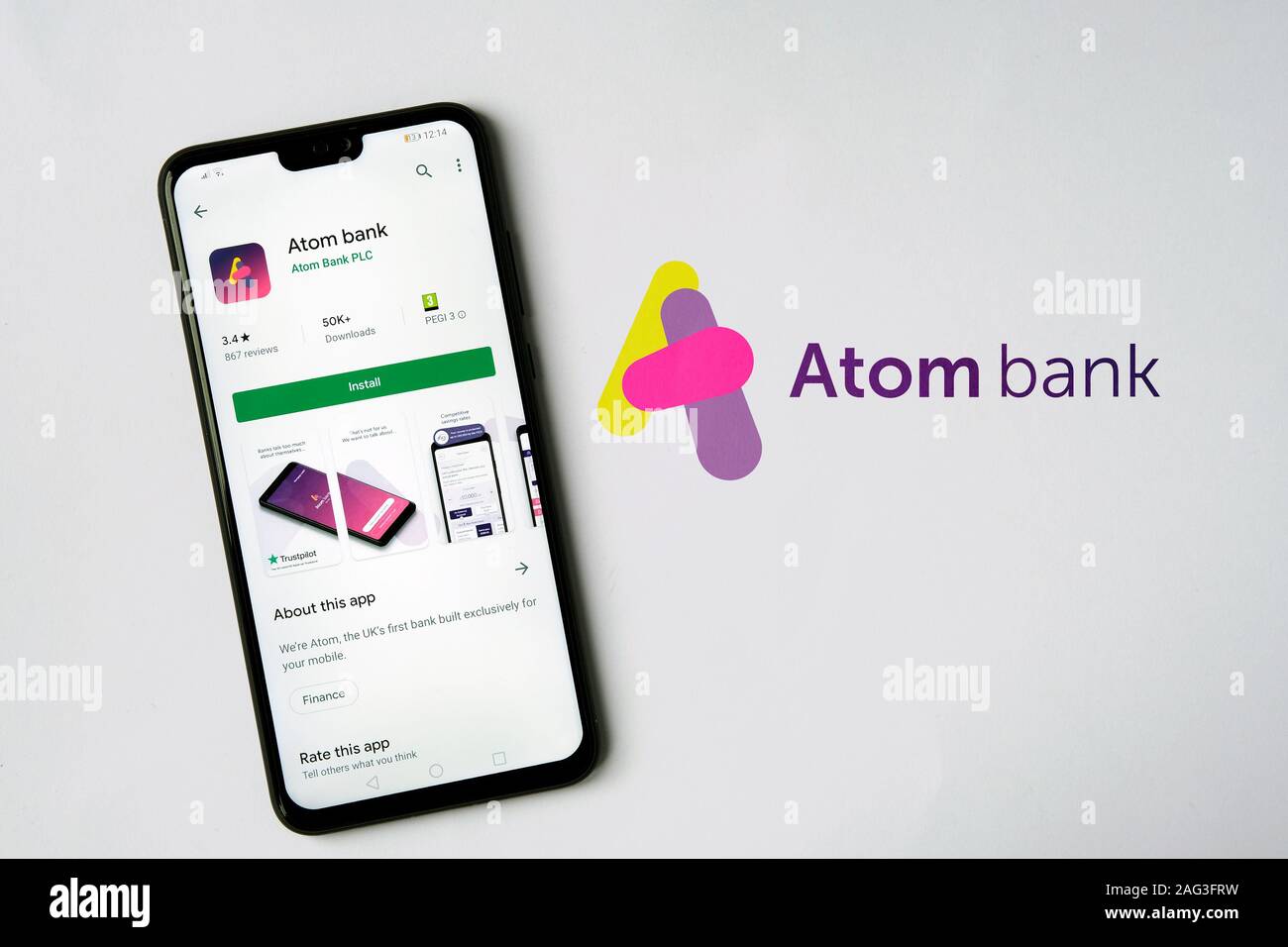 Atom le logo de la banque sur un papier et l'application sur l'écran du smartphone. Banque D'Images