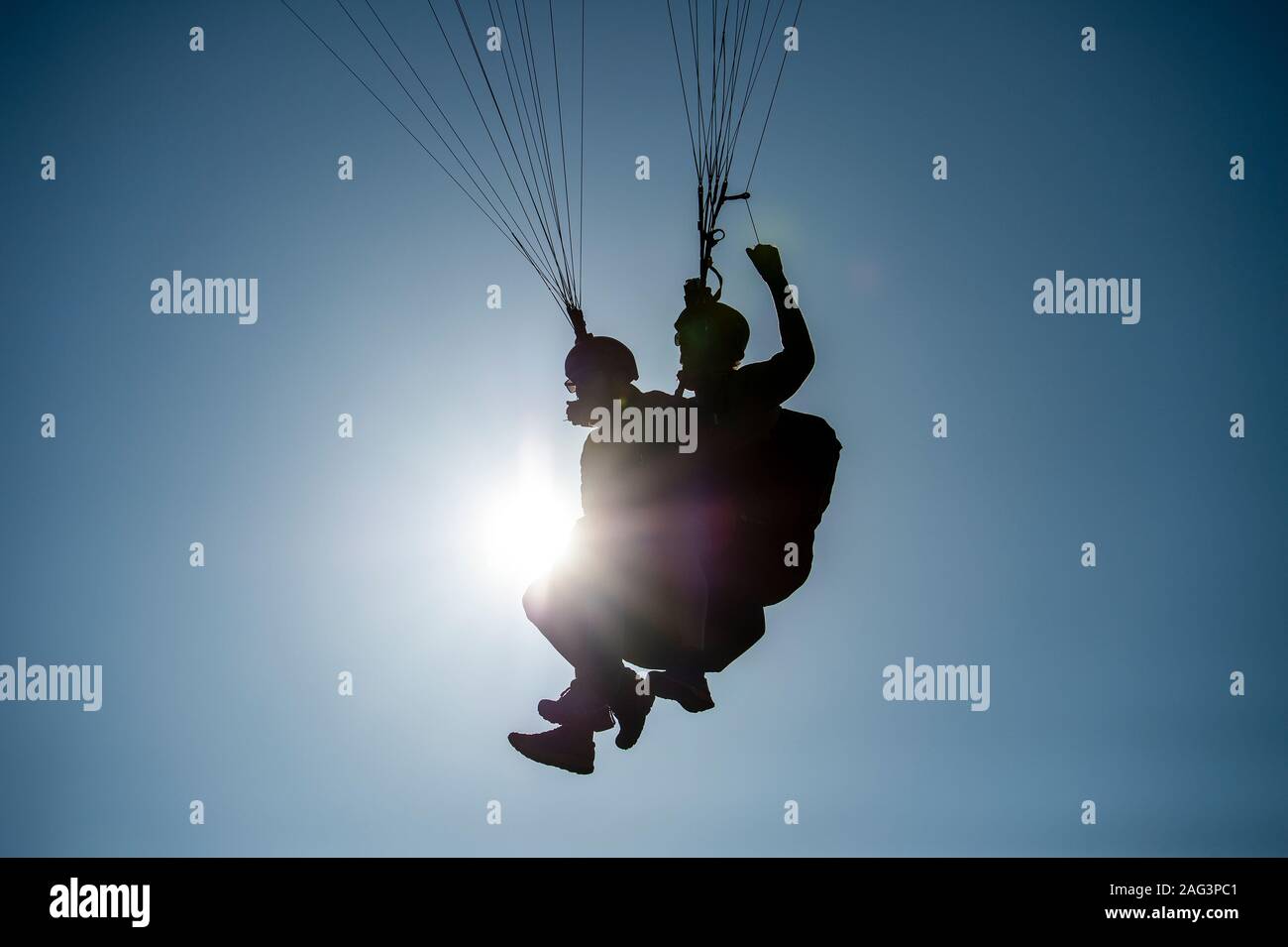 Pour les hommes dans une double tandem parapente. Ciel bleu ensoleillé. Banque D'Images