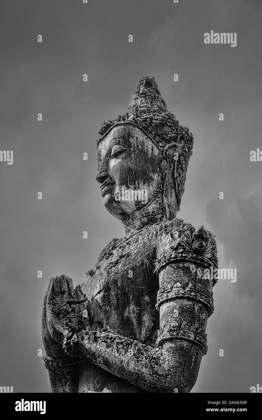 Photo en niveaux de gris d'une statue de Bouddha sous le ciel sombre Banque D'Images