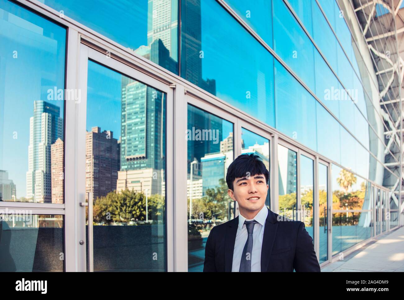 Smiling business man standing in front of office building Banque D'Images