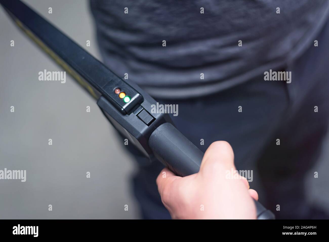Protection avec un détecteur de métal contrôler un homme d'armes et objets de métal avant d'entrer dans le ministère du trésor. Banque D'Images