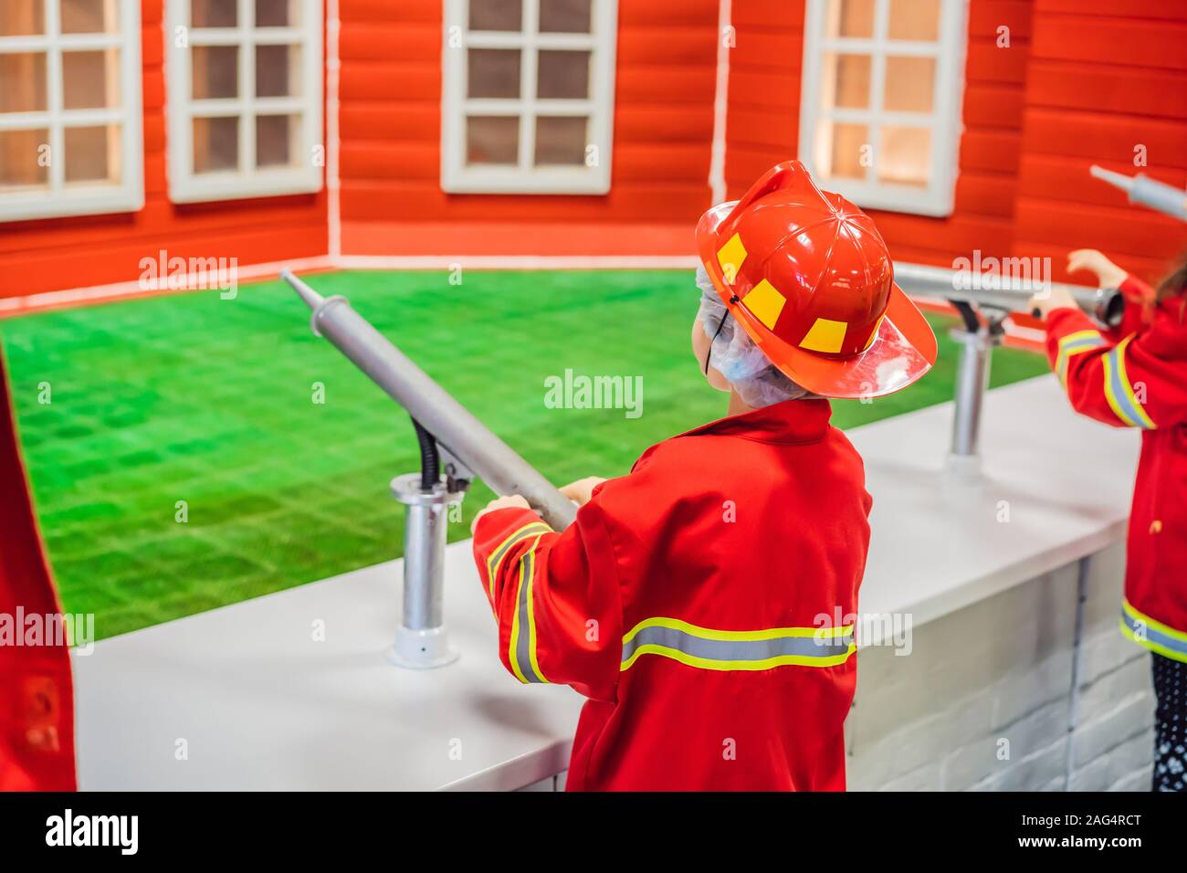 Cute toddler expressive avec équipement de pompier pompier jeu Banque D'Images