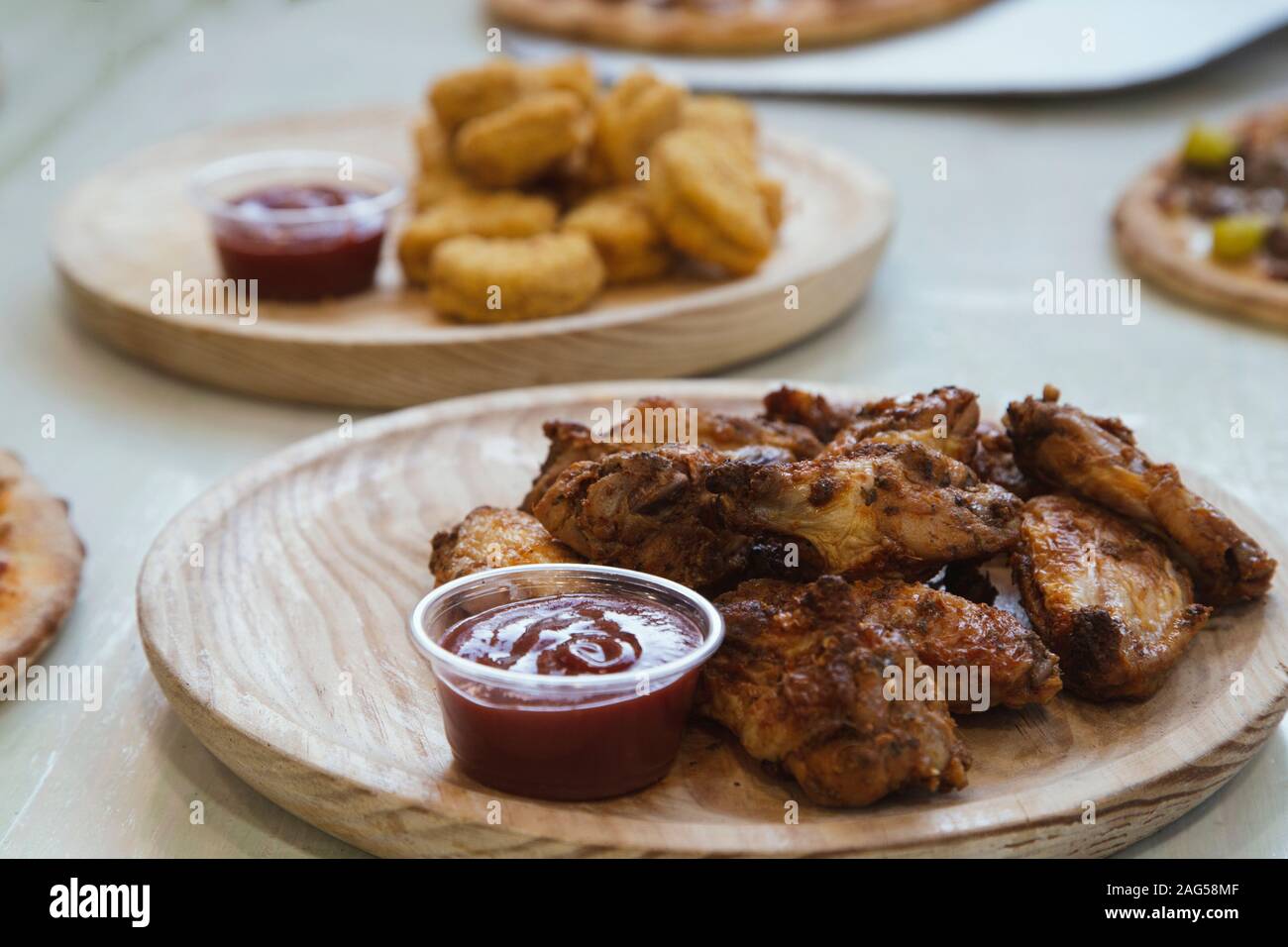 Close-up d'ailes de poulet avec sauce ketchup cap sur plaque de bois. Banque D'Images