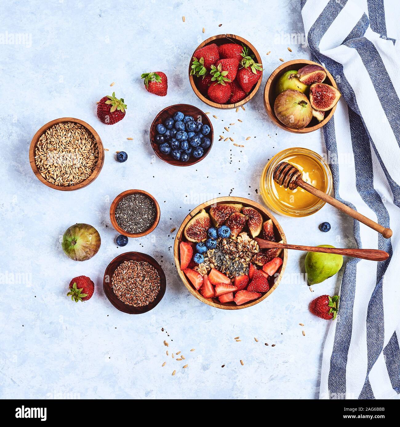 Petit-déjeuner sain et des produits pour le petit-déjeuner, le gruau avec des fruits et petits fruits, figues, bleuets, fraises, graines de lin et de chia, le miel. Vue d'en haut Banque D'Images