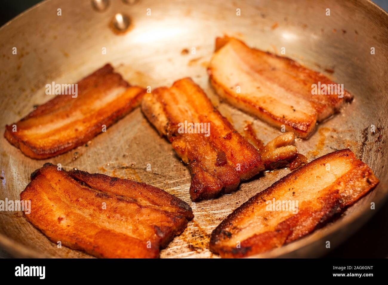 Gros plan de la cuisson du bacon dans la poêle. Banque D'Images