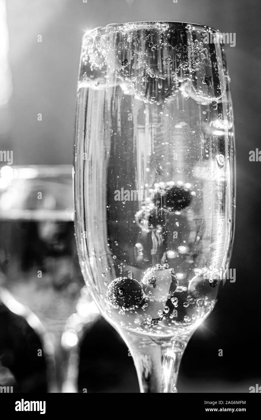 Sparkle vin en verre avec des baies de groseille rouge. Noir et blanc. Banque D'Images