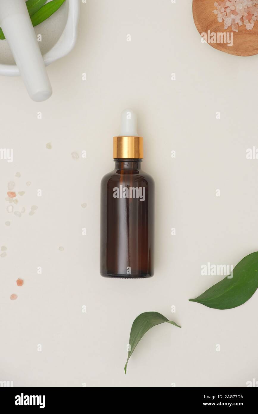 Concept spa, massage avec une cuillère de sel dans les bouteilles et d'huile essentielle avec de petits quitter Banque D'Images