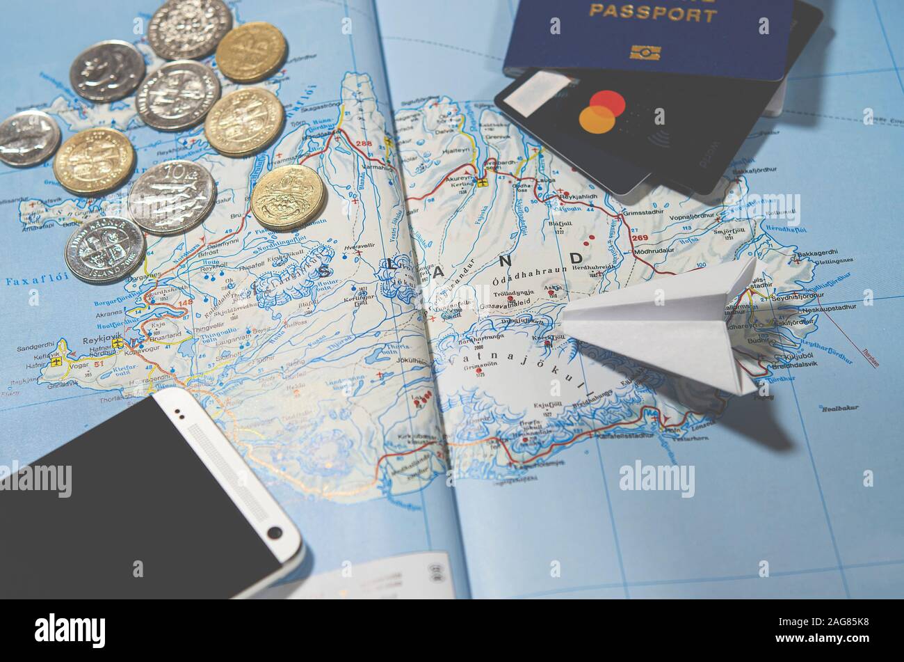 L'avion, smartphone, passeport biométrique, dollars, monnaie et cartes de crédit reposent sur une carte Banque D'Images