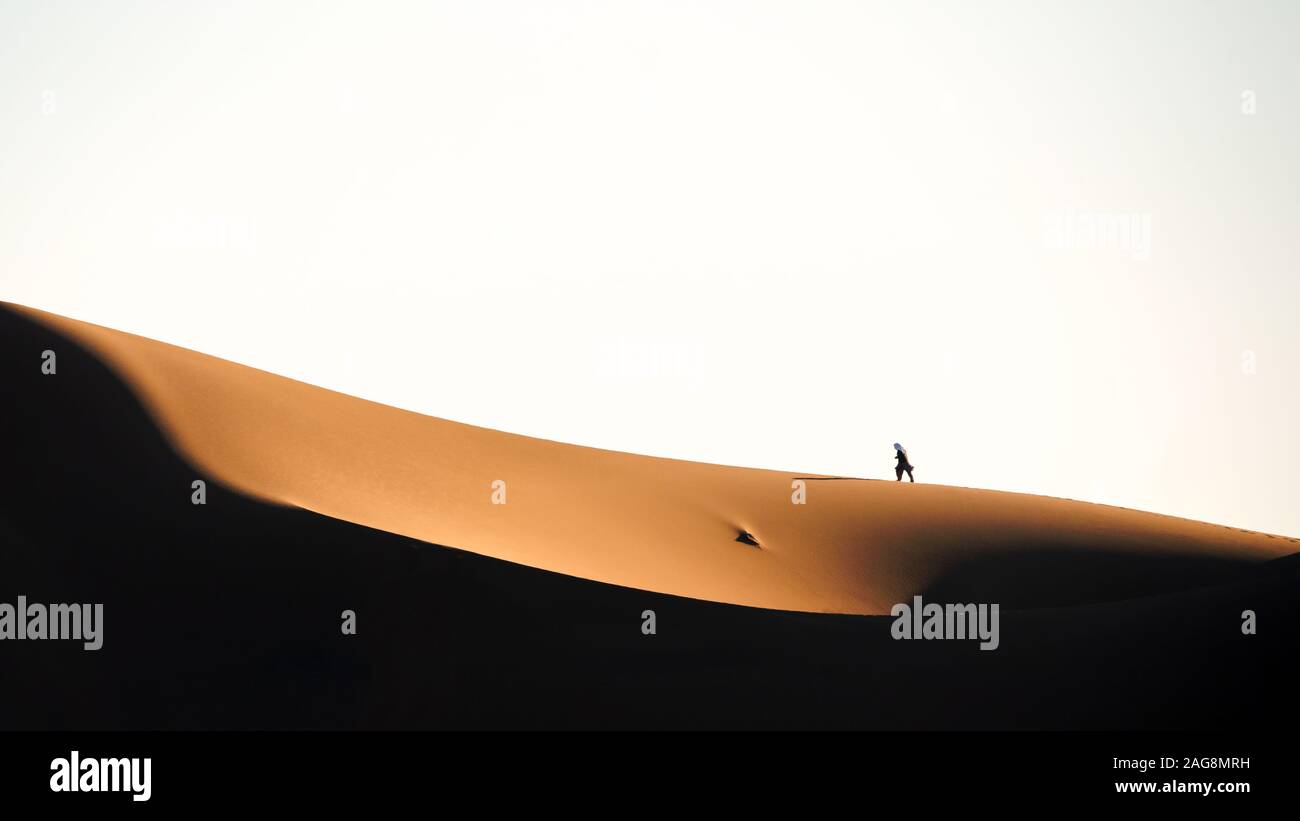 L'homme qui marche sur les dunes de sable dans le désert lut Banque D'Images
