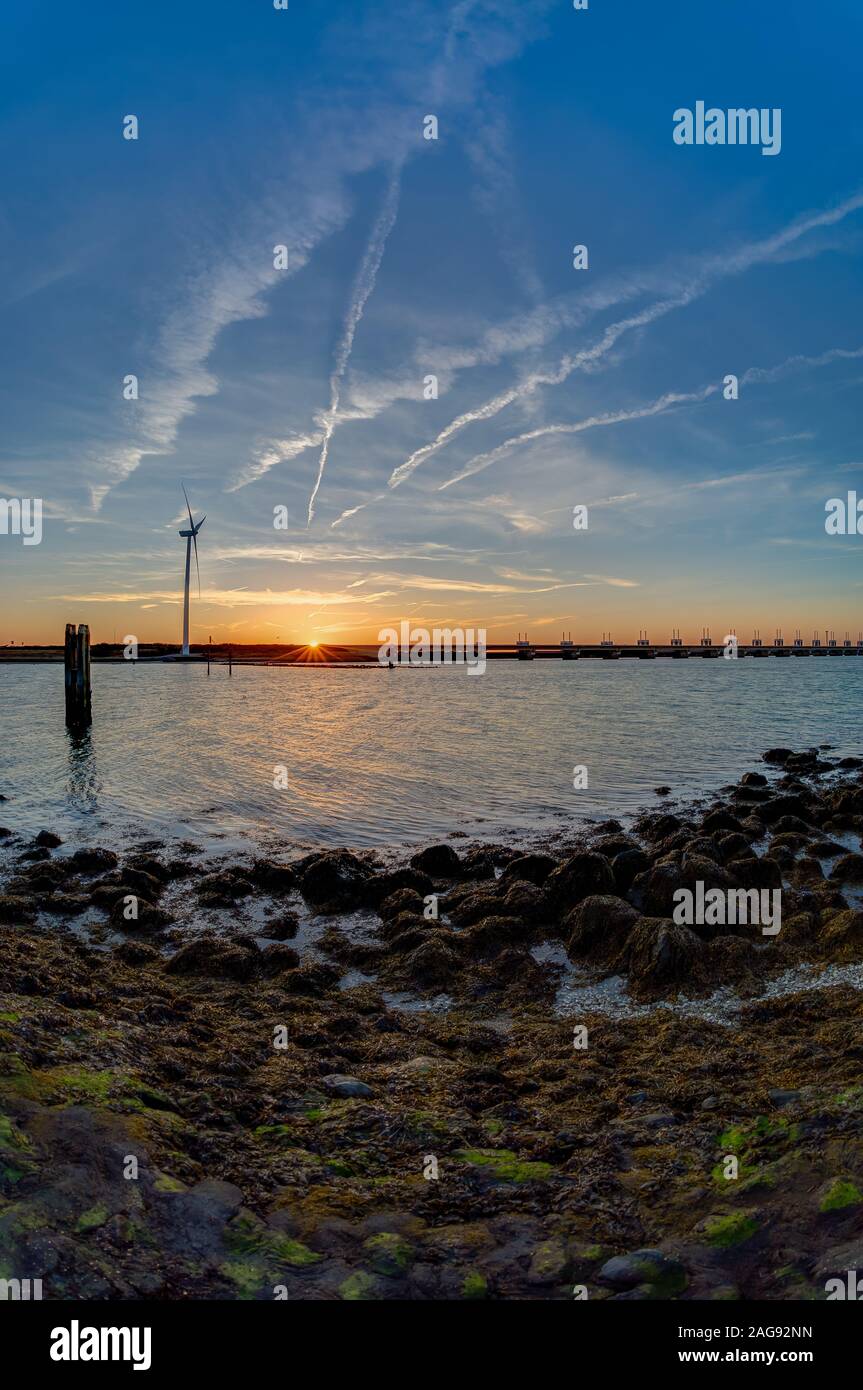 Photo verticale d'un coucher de soleil au-dessus de l'océan à la barrière de tempête, Zeeland, pays-Bas Banque D'Images