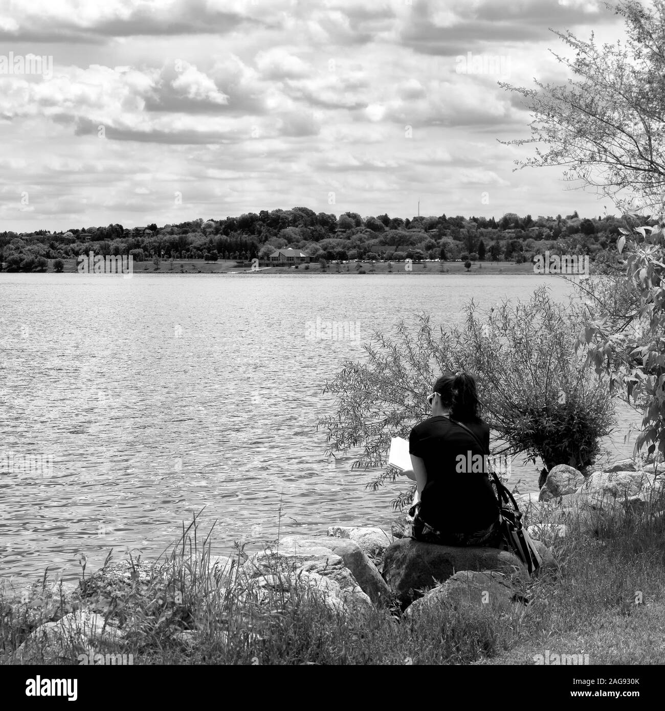 Canada, Barrie, Ontario, pause déjeuner dans le parc, une femme est la lecture au mois de juin 2019 Banque D'Images