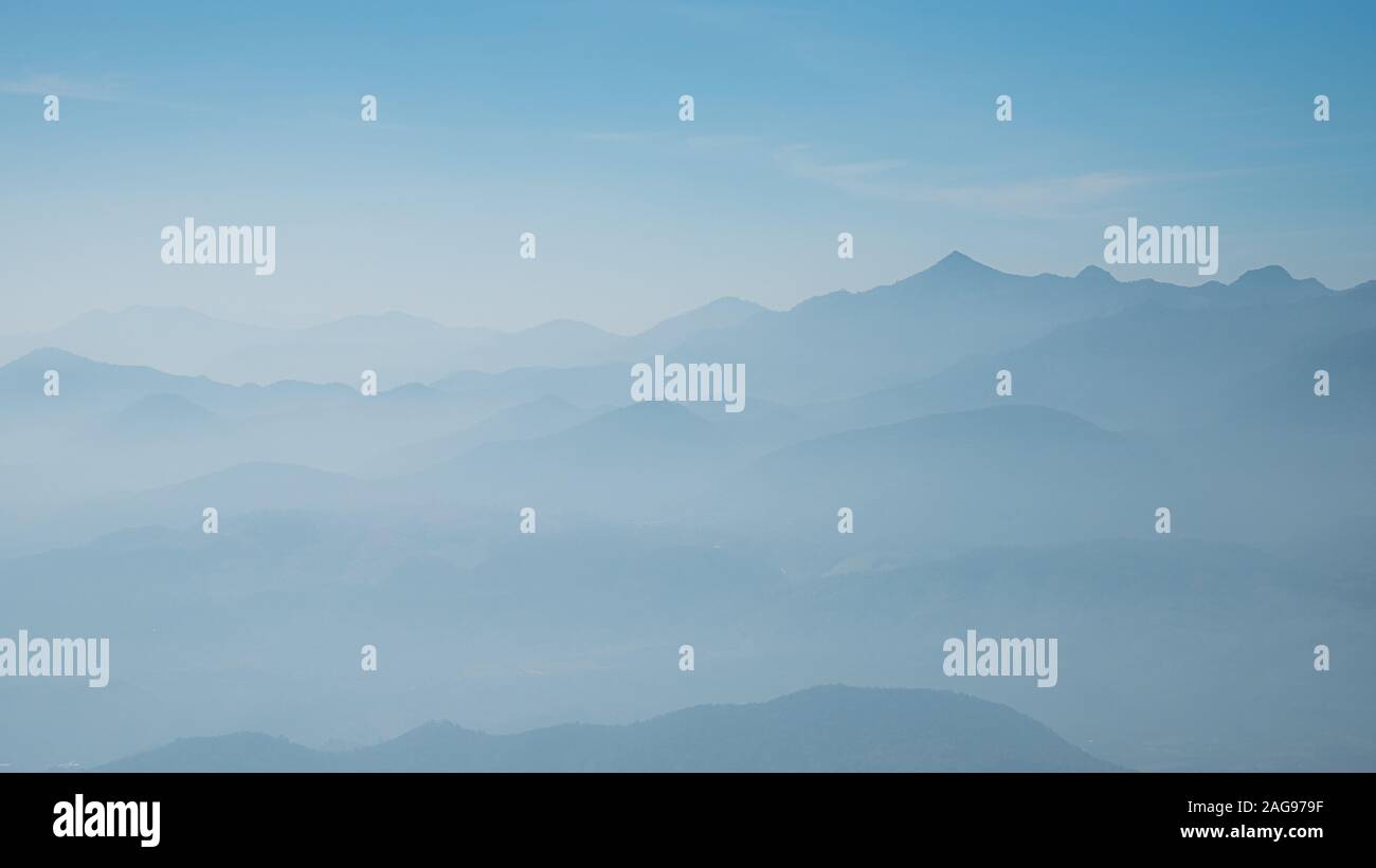 Misty Mountain silhouette ciel bleu Banque D'Images