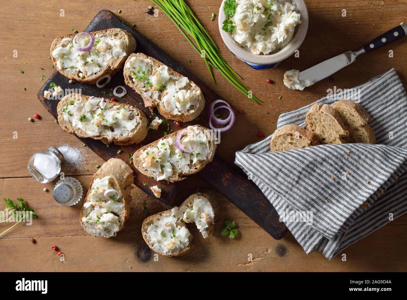 Saindoux copieux à Greaves et oignons comme un propagation sur les aliments complets baguette, servi sur une table en bois rustique Banque D'Images
