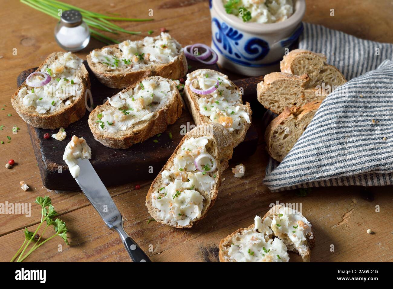 Saindoux copieux à Greaves et oignons comme un propagation sur les aliments complets baguette, servi sur une table en bois rustique Banque D'Images