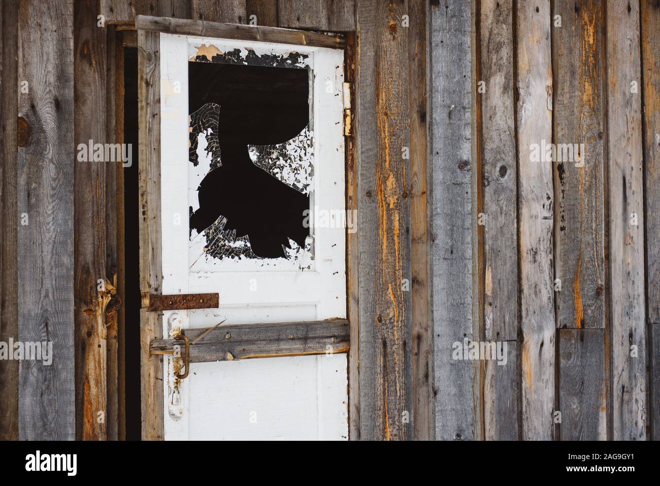 Une vitre cassée dans l'embrasure de la fenêtre, avec des bords dangereux, d'éclats et de l'écaillage de la peinture. Banque D'Images