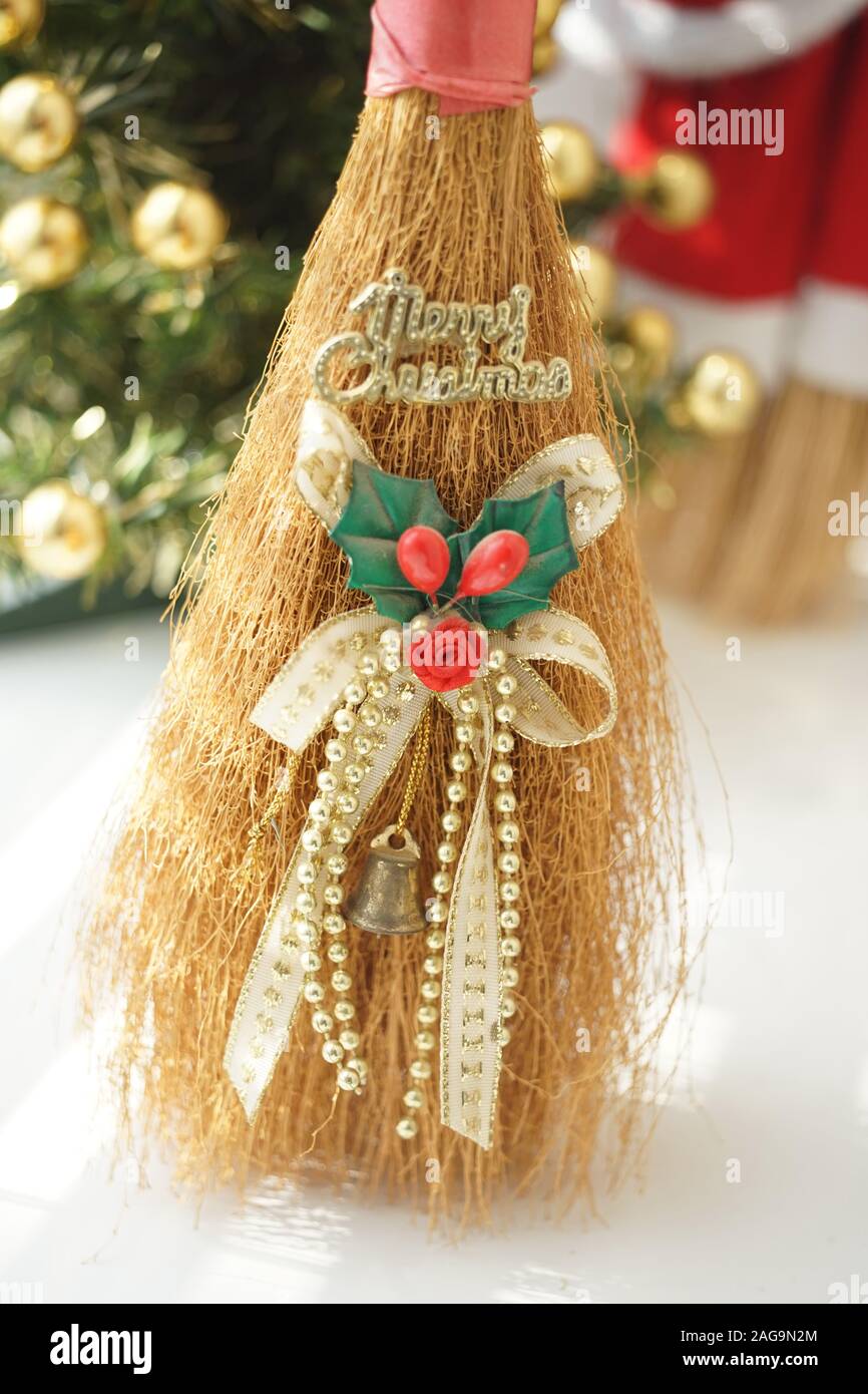 Jouet balai au décor et texte d'or Joyeux Noël sur le tableau blanc. Banque D'Images