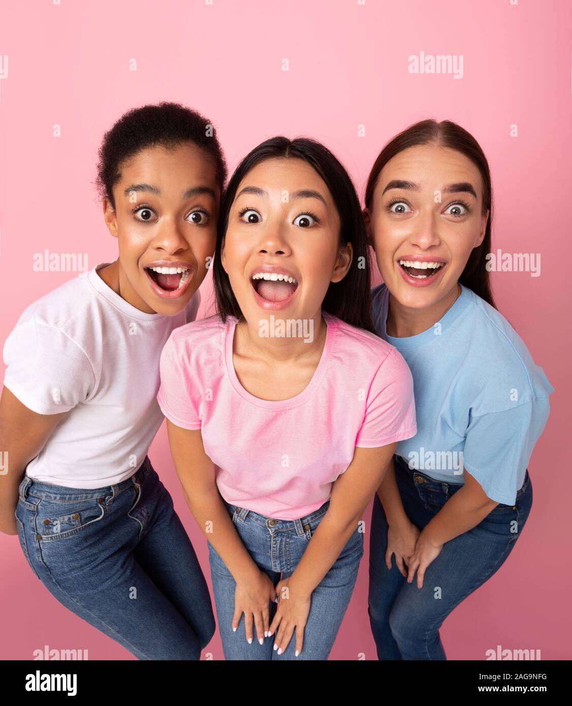 Trois Funny Girls Looking at Camera, permanent, High-Angle fond rose Banque D'Images