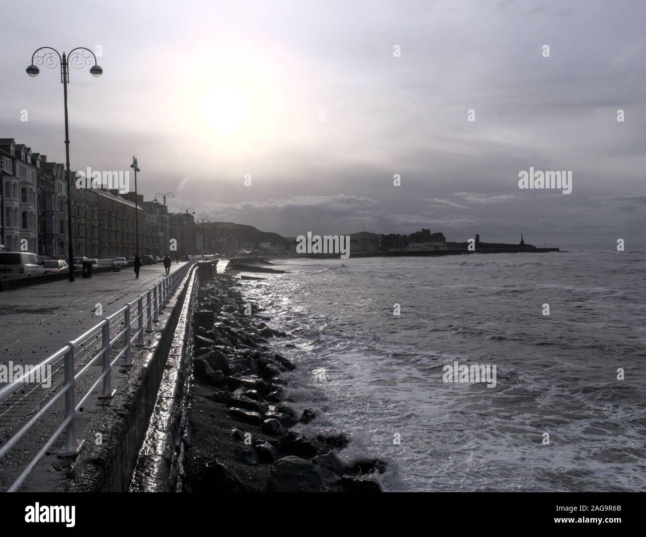 Front de mer d''Aberystwyth en silhouette sur un jour brumeux humide atmosphérique avec la ville château et monument commémoratif de guerre à l'arrière-plan Banque D'Images