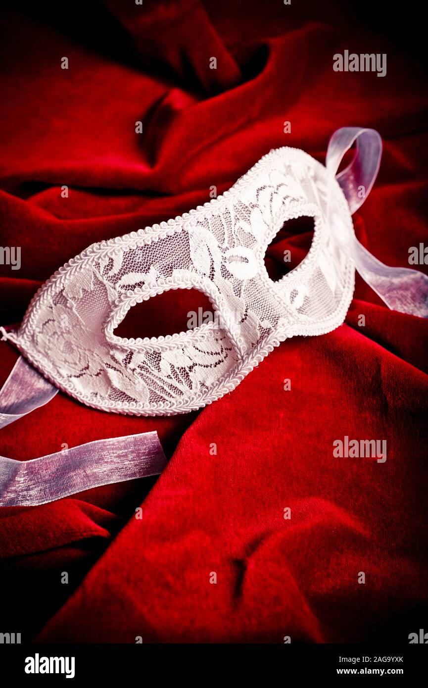 masque élégant à la décoration blanche sur velours rouge Banque D'Images