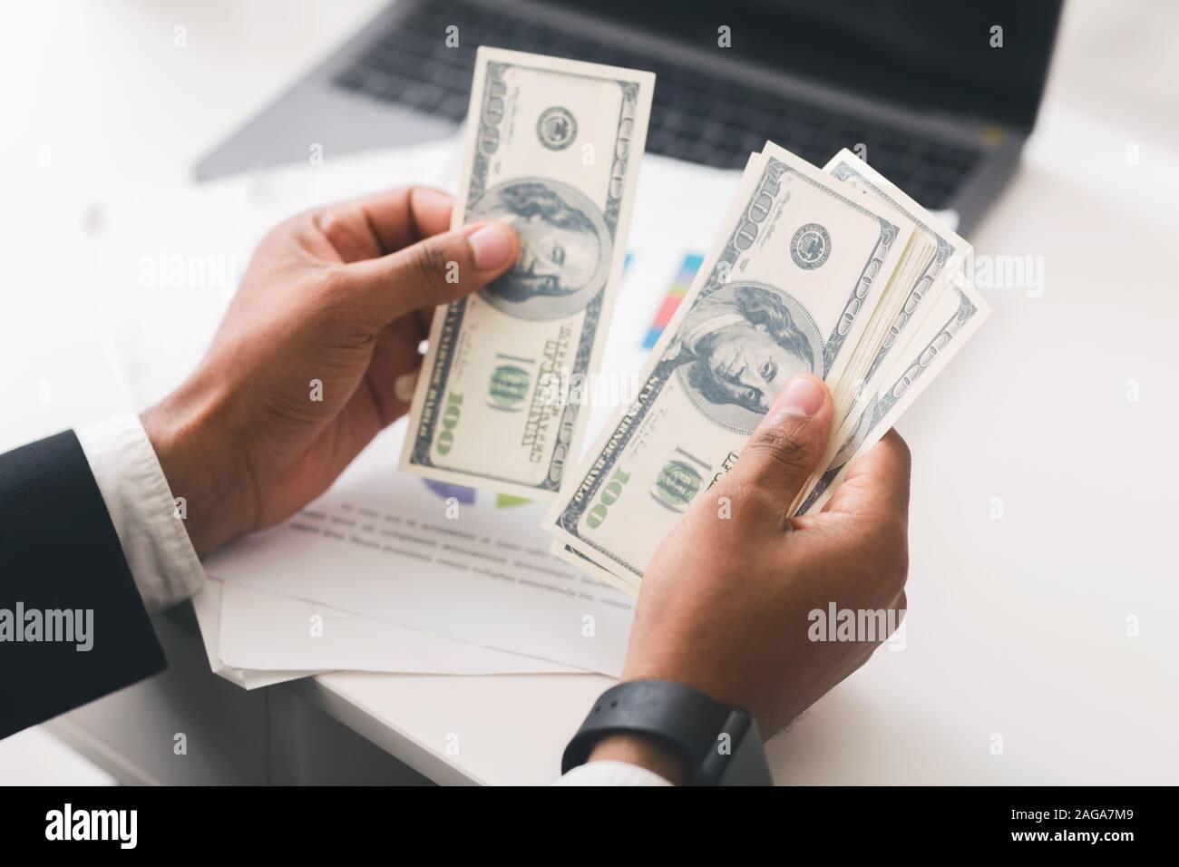 Portrait of businessman compter les billets de dollar sur le lieu de travail Banque D'Images