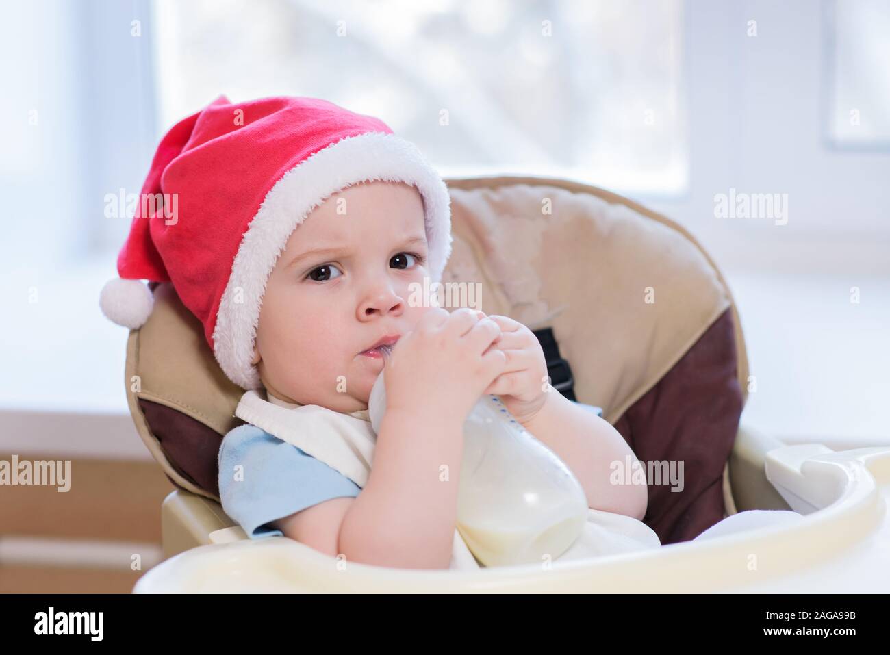 Tout-petit mange à table dans un chapeau de Noël Banque D'Images