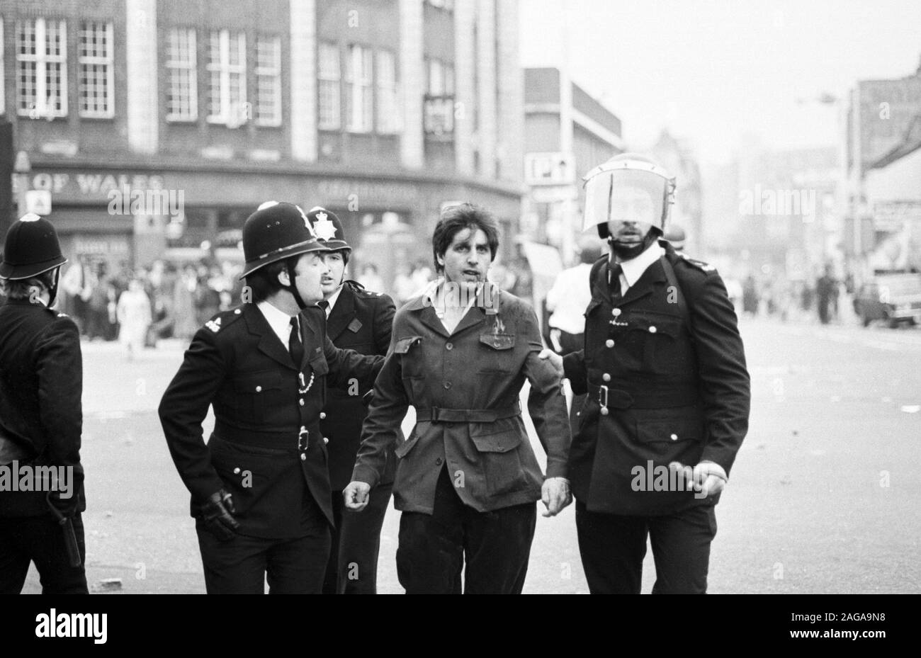 La police en uniforme entraînent un collègue blessé au cours d'émeutes à Brixton, Londres. Banque D'Images