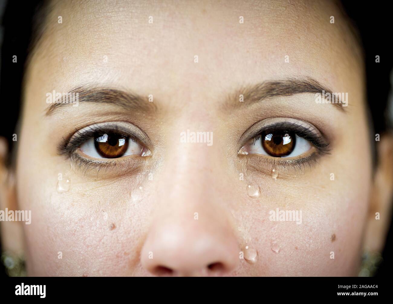 Gros plan d'une femme émotif qui pleure tout en regardant la caméra - concept dépression, anxiété Banque D'Images