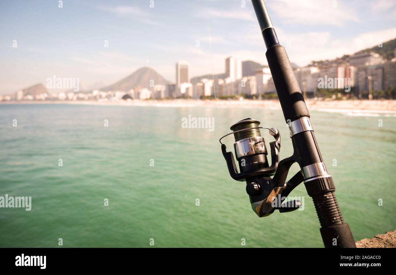 Pêche à Rio. Les point sur le premier plan la canne à pêche avec la Praia do Copacabana à Rio de Janeiro, Brésil, visible à l'arrière-plan flou. Banque D'Images