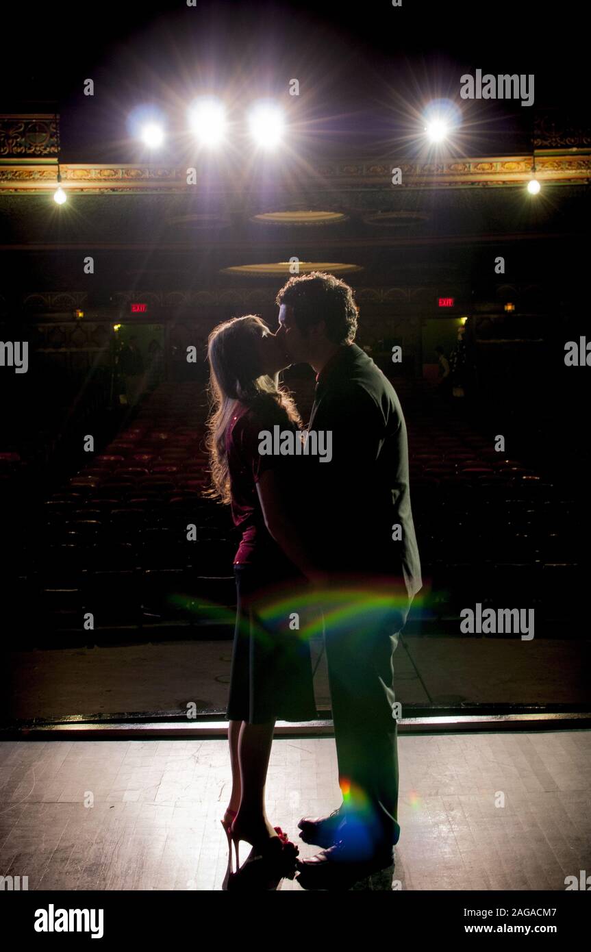 Plan vertical d'un mâle et d'une femelle embrassant chacun autre tout en se tenant sur la scène dans le théâtre Banque D'Images