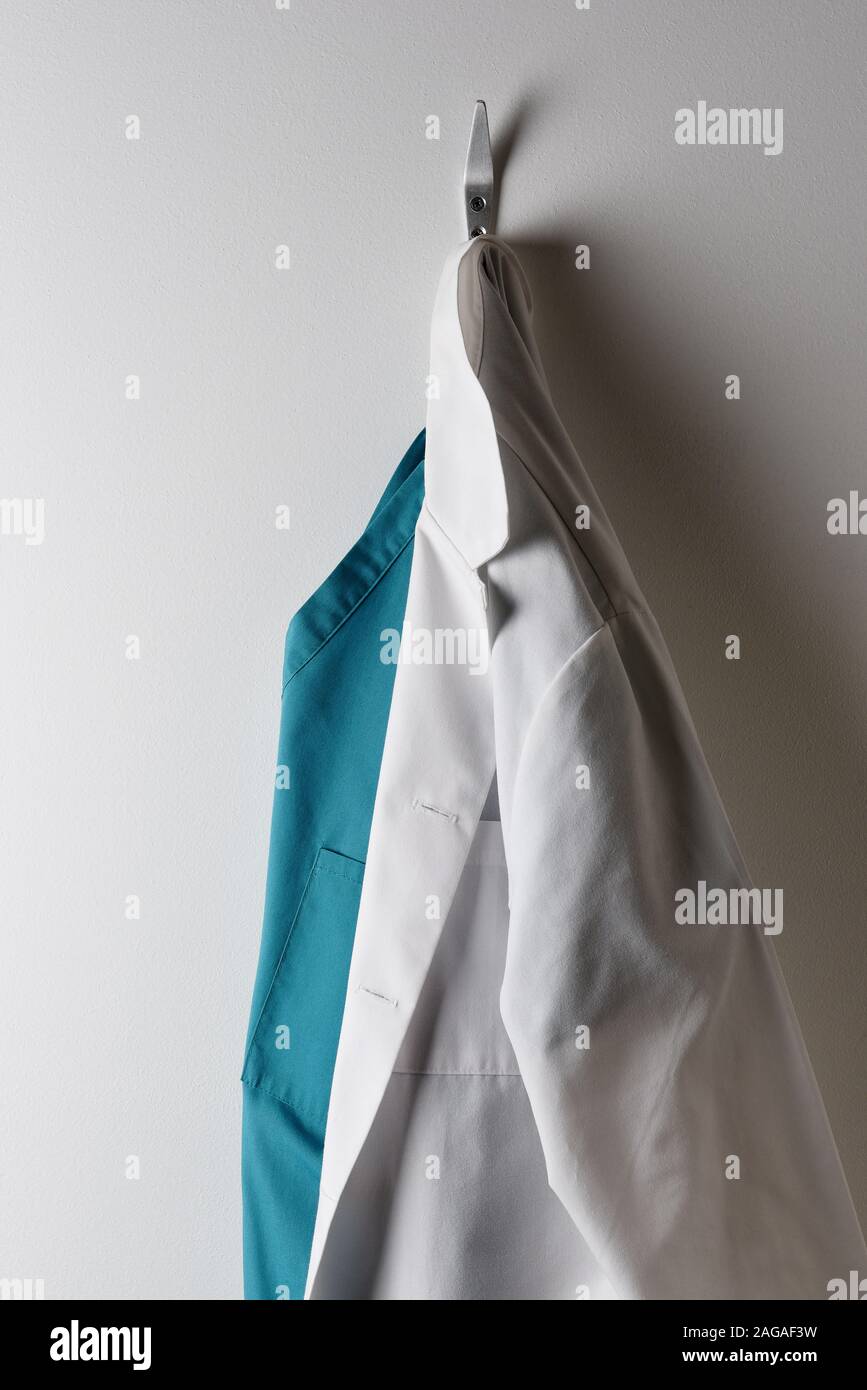 Les médecins d'un sarrau blanc et vert des gommages corporels suspendu à un crochet. Banque D'Images