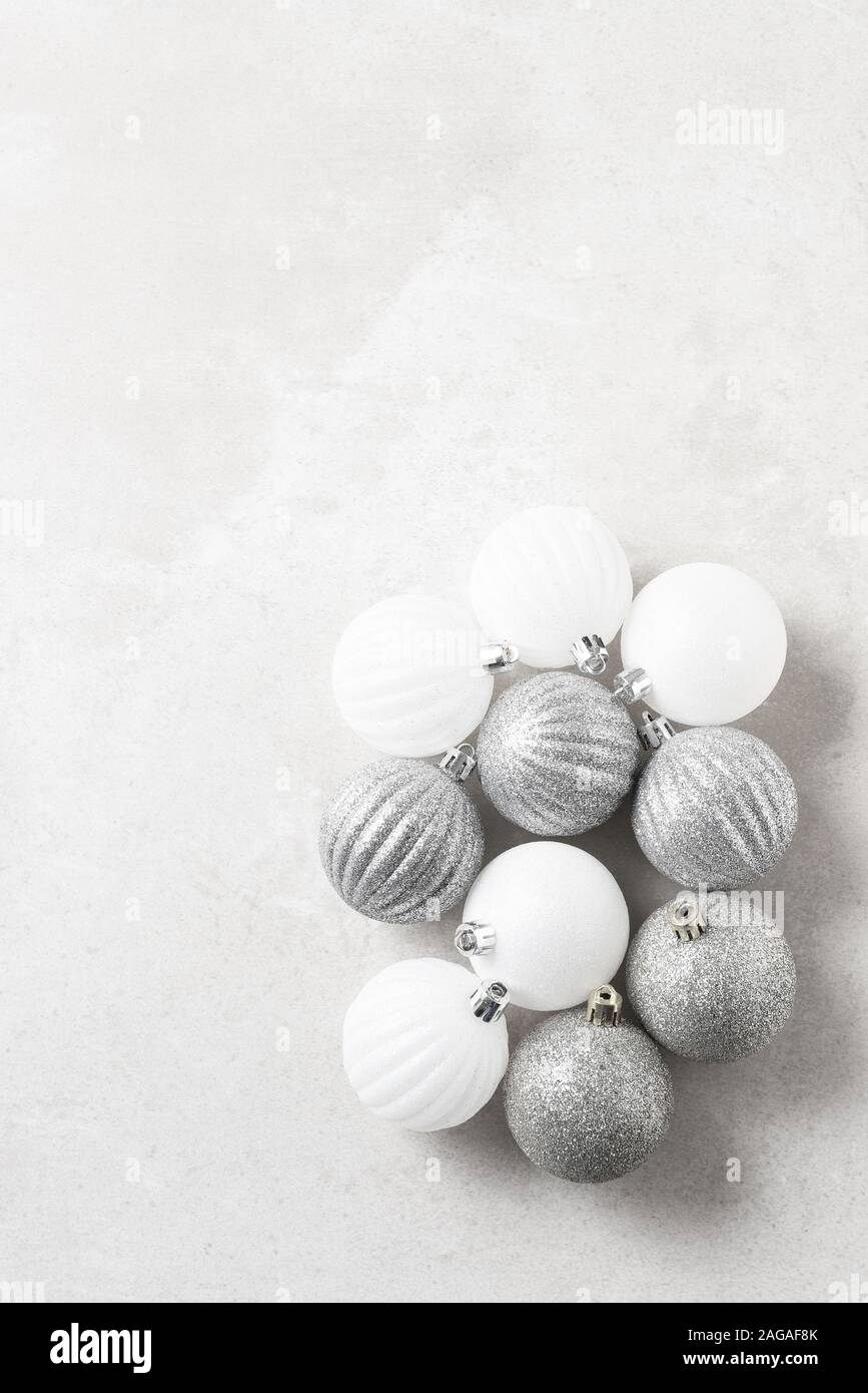 Un groupe d'argent et ornements d'arbre de Noël blanc sur une surface gris clair. Avec copie espace vertical. Banque D'Images