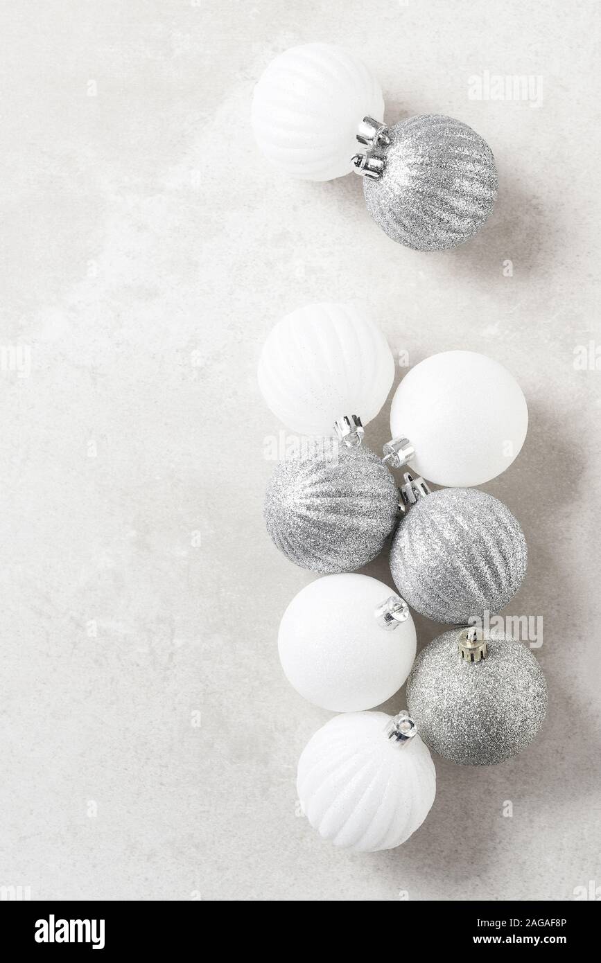 Arbre de Noël argent et blanc boules sur une surface gris tacheté. Avec copie espace vertical. Banque D'Images