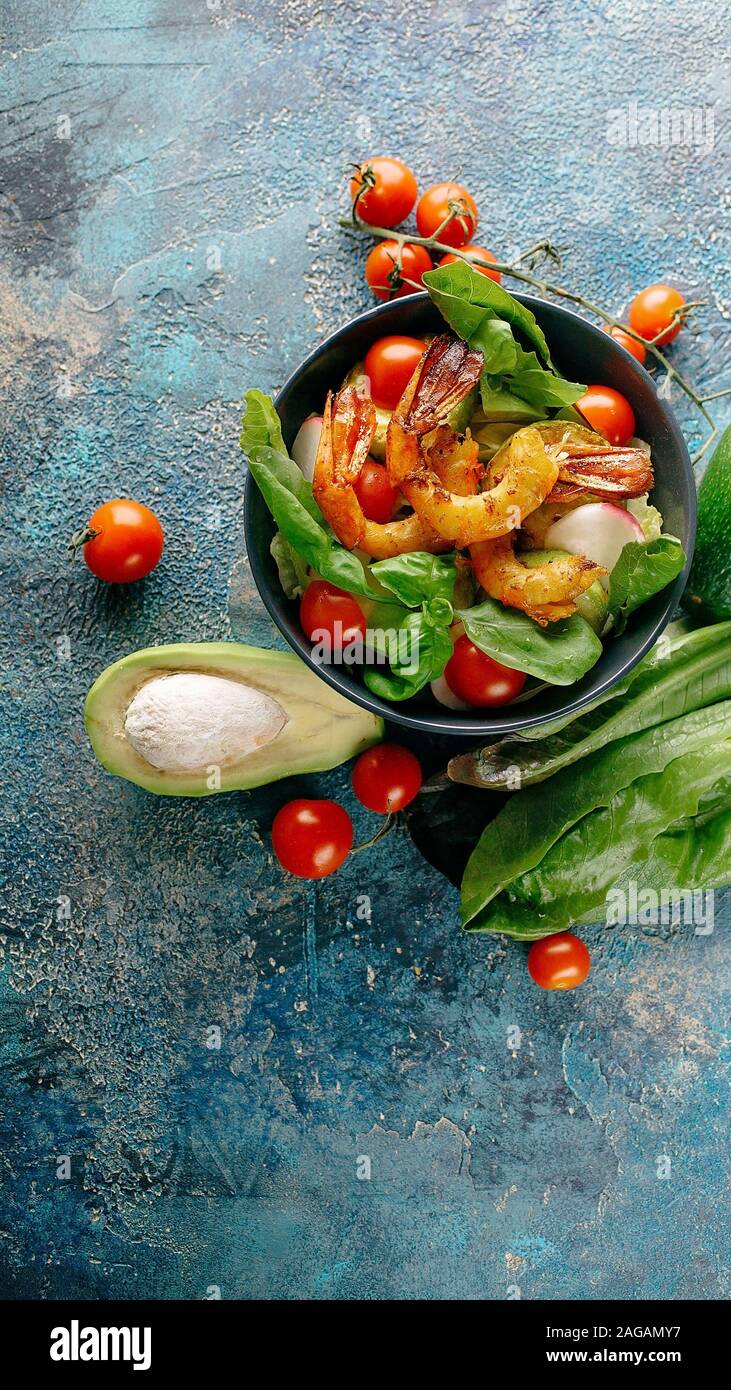 Shot verticale salade appétissante avec crevettes frites, avocat, radis et le basilic. Savoureux et sain de fruits de mer. Banque D'Images