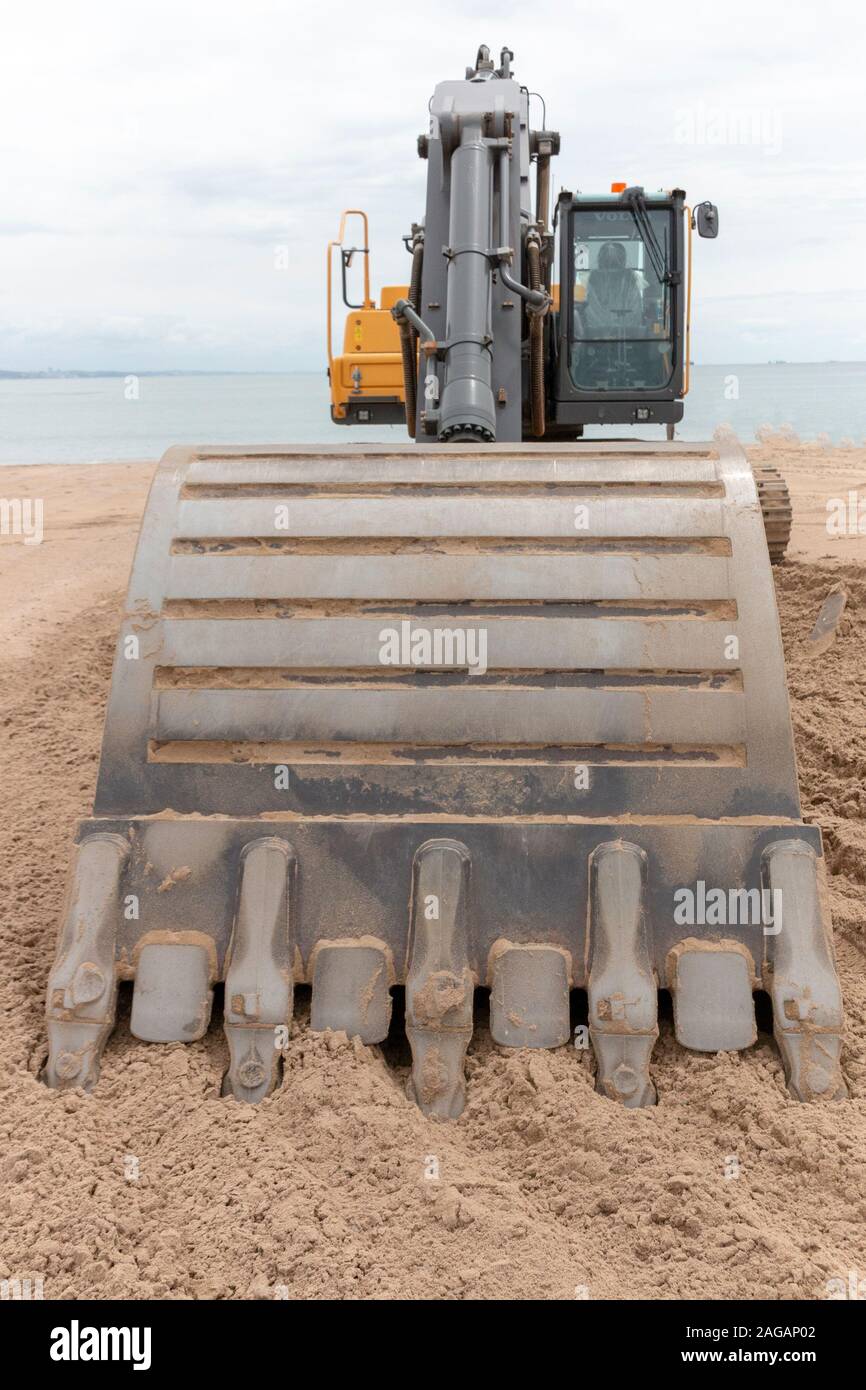 Une vue en gros plan d'une niveleuse volvo creuser le sable sur la plage de Durban Banque D'Images
