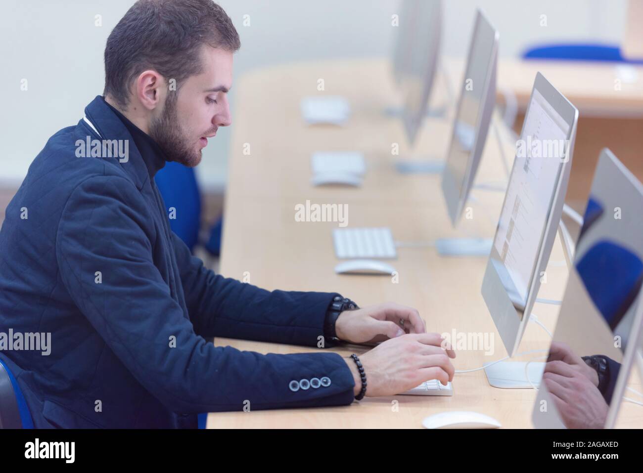La programmation. L'homme travaillant sur ordinateur dans ce bureau, assis à 24 Codes d'écriture. Le code à entrer des données de programmation, de travailler sur le logiciel en projet développemen Banque D'Images