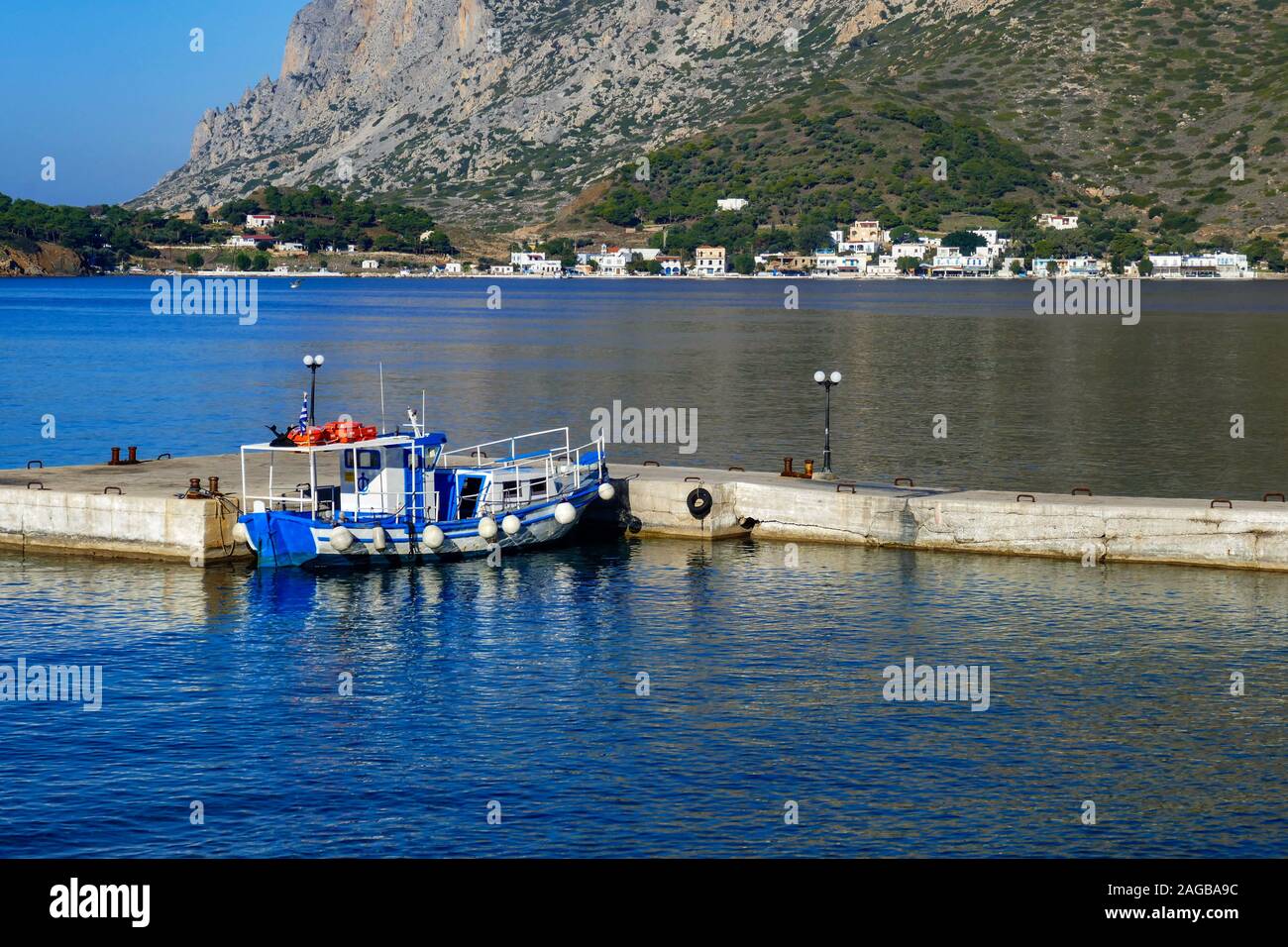 Taxi Bleu et blanc-bleu calme, bateau matin à Myrties Kalymnos, Grèce jetée. Telendos dans la distance. Banque D'Images