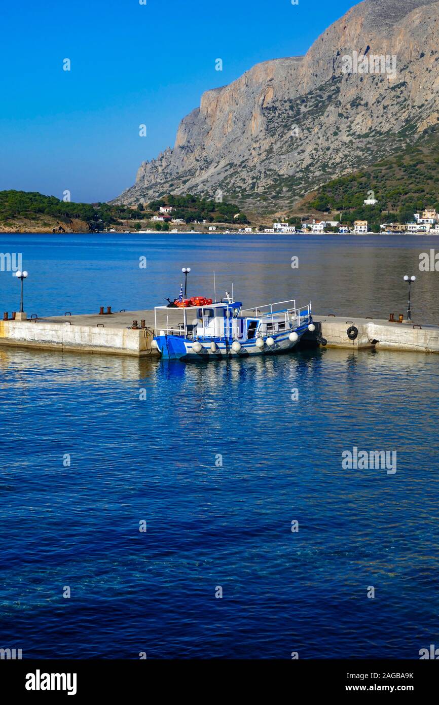 Taxi Bleu et blanc-bleu calme, bateau matin à Myrties Kalymnos, Grèce jetée. Telendos dans la distance. Banque D'Images