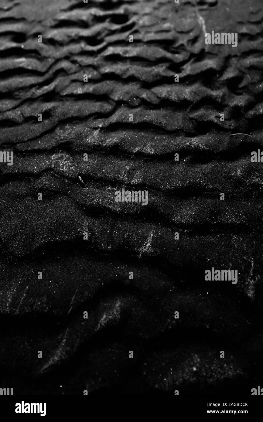 Arrière-plan en niveaux de gris frais de sable noir superposé humide - super pour l'arrière-plan ou le fond d'écran Banque D'Images