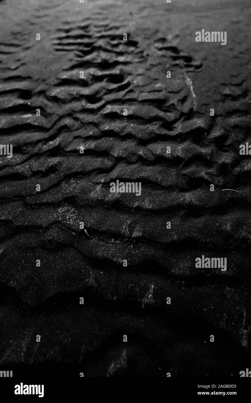Arrière-plan en niveaux de gris frais de sable noir superposé humide - super pour l'arrière-plan ou le fond d'écran Banque D'Images