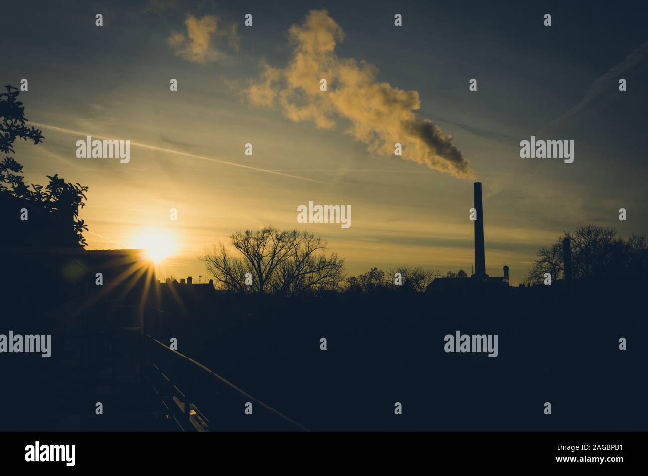 Image de cheminée industrielle et la fumée pendant le lever du soleil Banque D'Images